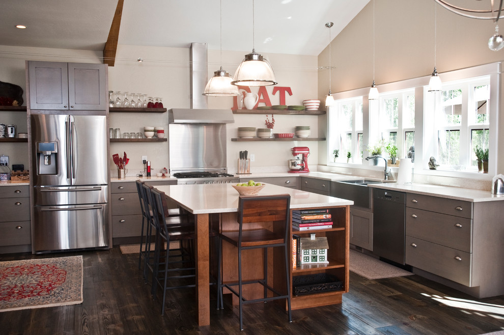 Inspiration for a large transitional l-shaped dark wood floor and brown floor open concept kitchen remodel with a farmhouse sink, flat-panel cabinets, gray cabinets, quartz countertops, stainless steel appliances and an island