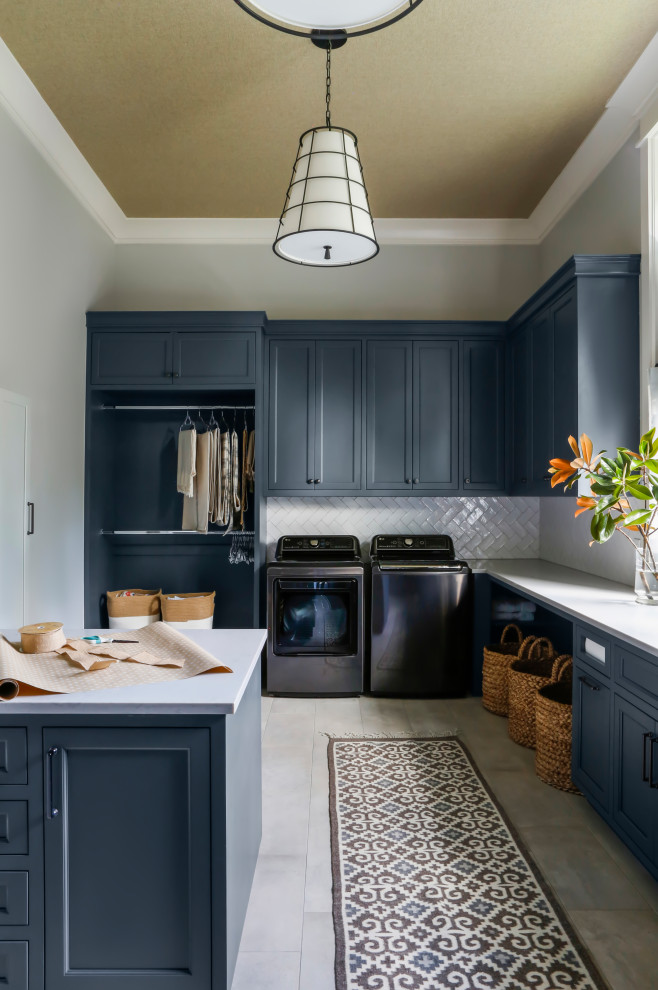 Large farmhouse u-shaped utility room in Nashville with a submerged sink, shaker cabinets, blue cabinets, engineered stone countertops, white splashback, metro tiled splashback, grey walls, porcelain flooring, a side by side washer and dryer, grey floors, grey worktops and a wallpapered ceiling.