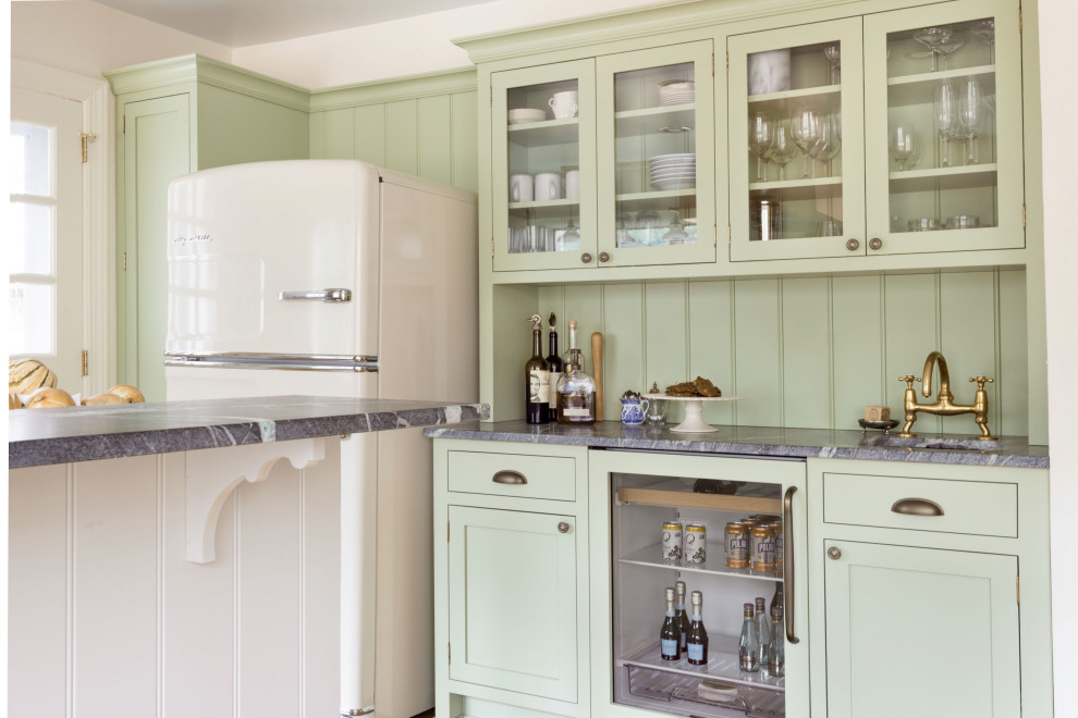 Immagine di una cucina ad U rustica con ante in stile shaker, ante verdi, top in saponaria e top nero