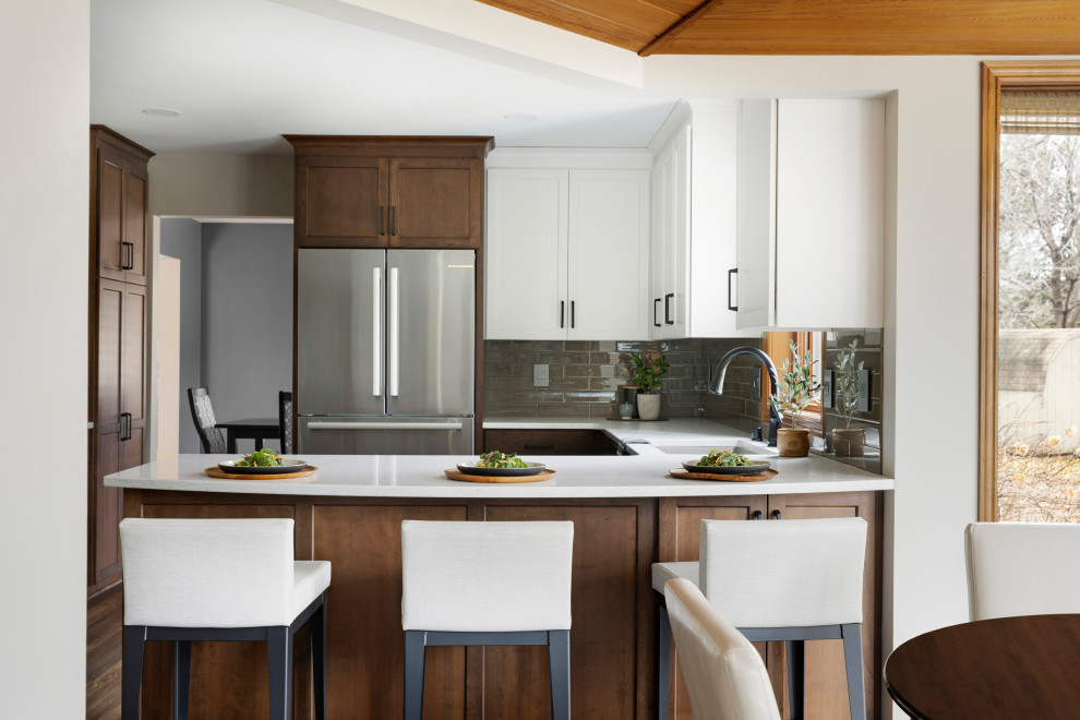 Large contemporary u-shaped kitchen/diner in Minneapolis with a single-bowl sink, recessed-panel cabinets, medium wood cabinets, quartz worktops, beige splashback, glass tiled splashback, stainless steel appliances, vinyl flooring, a breakfast bar, brown floors, white worktops and a wood ceiling.