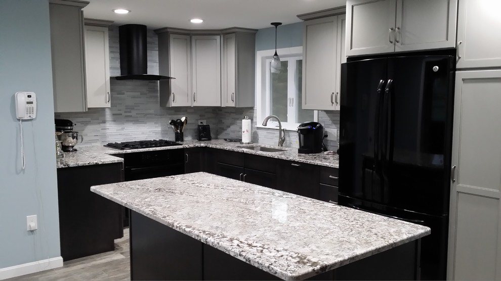 This is an example of a mid-sized transitional u-shaped open plan kitchen in Boston with an undermount sink, shaker cabinets, black cabinets, granite benchtops, grey splashback, glass tile splashback, stainless steel appliances, slate floors, with island and grey floor.