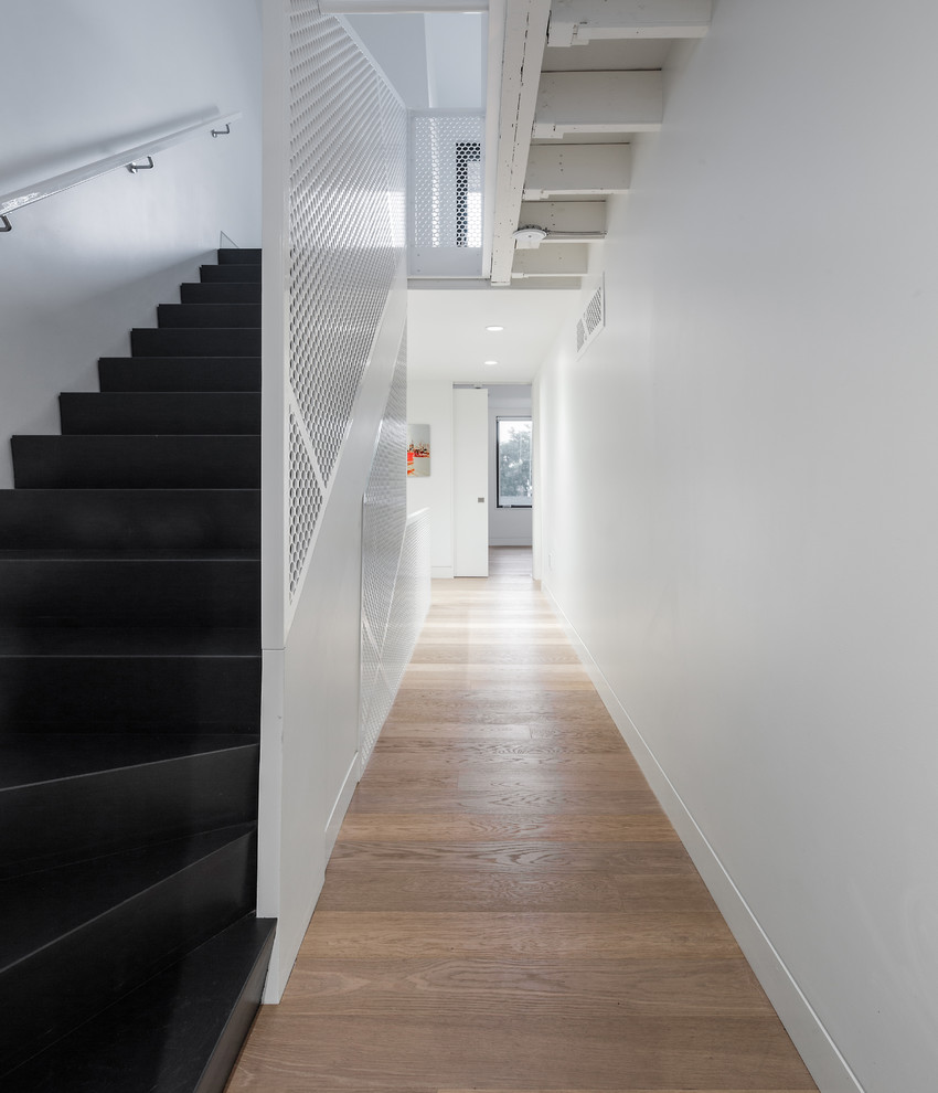Design ideas for a mid-sized contemporary hallway in Toronto with white walls and light hardwood floors.