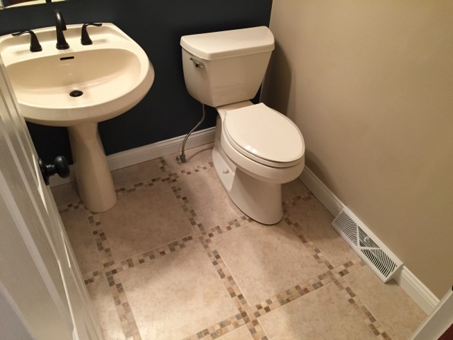 Small transitional powder room in Cleveland with a pedestal sink, a two-piece toilet, beige tile, porcelain tile, blue walls and porcelain floors.