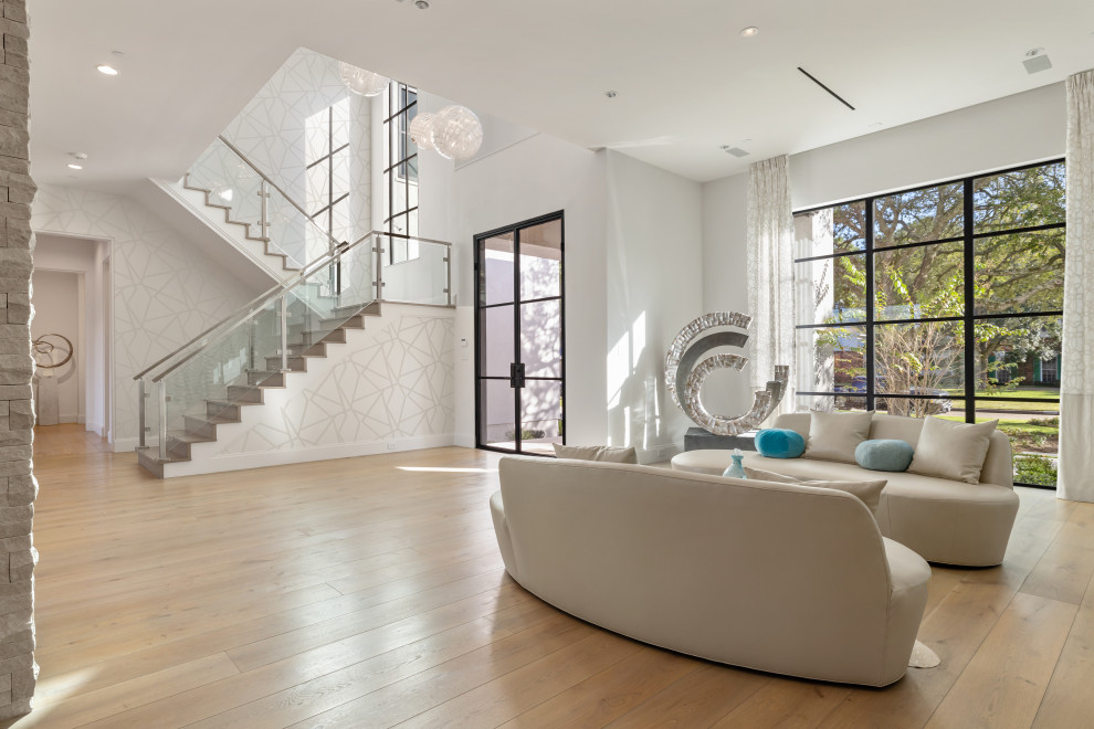 Immagine di un grande soggiorno contemporaneo con pareti bianche e parquet chiaro