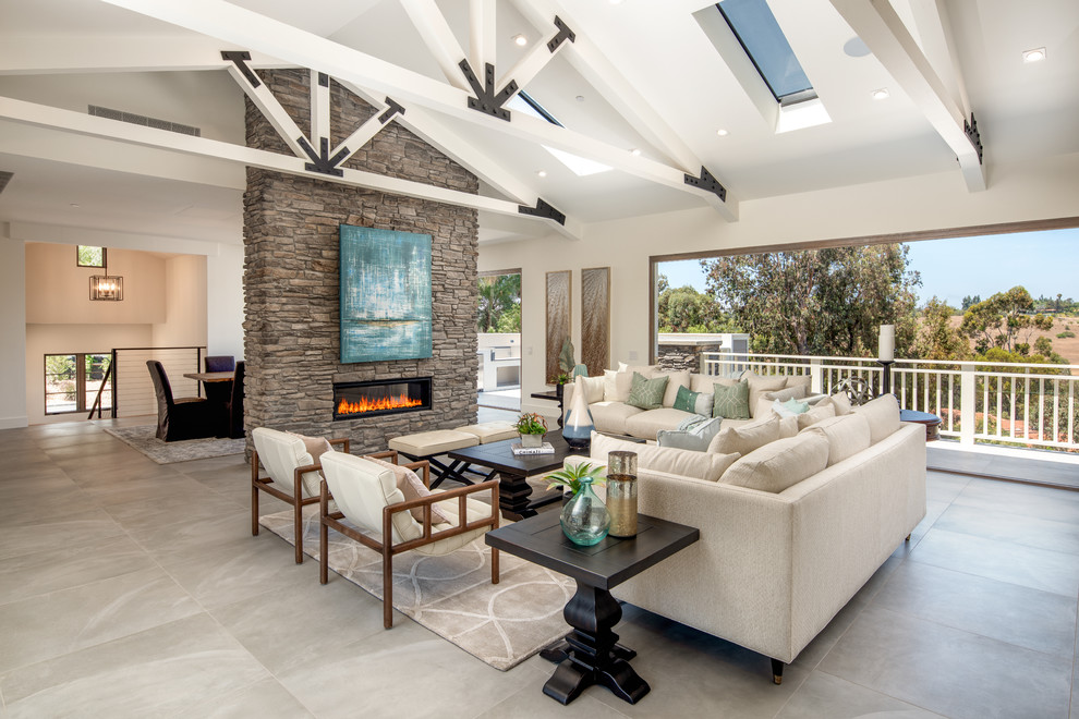 Design ideas for a transitional open concept family room in San Diego with white walls, a ribbon fireplace, a stone fireplace surround and grey floor.