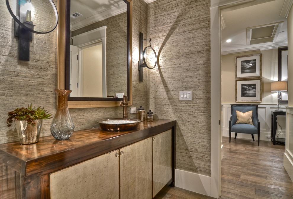 This is an example of a traditional powder room in Orange County with brown benchtops.