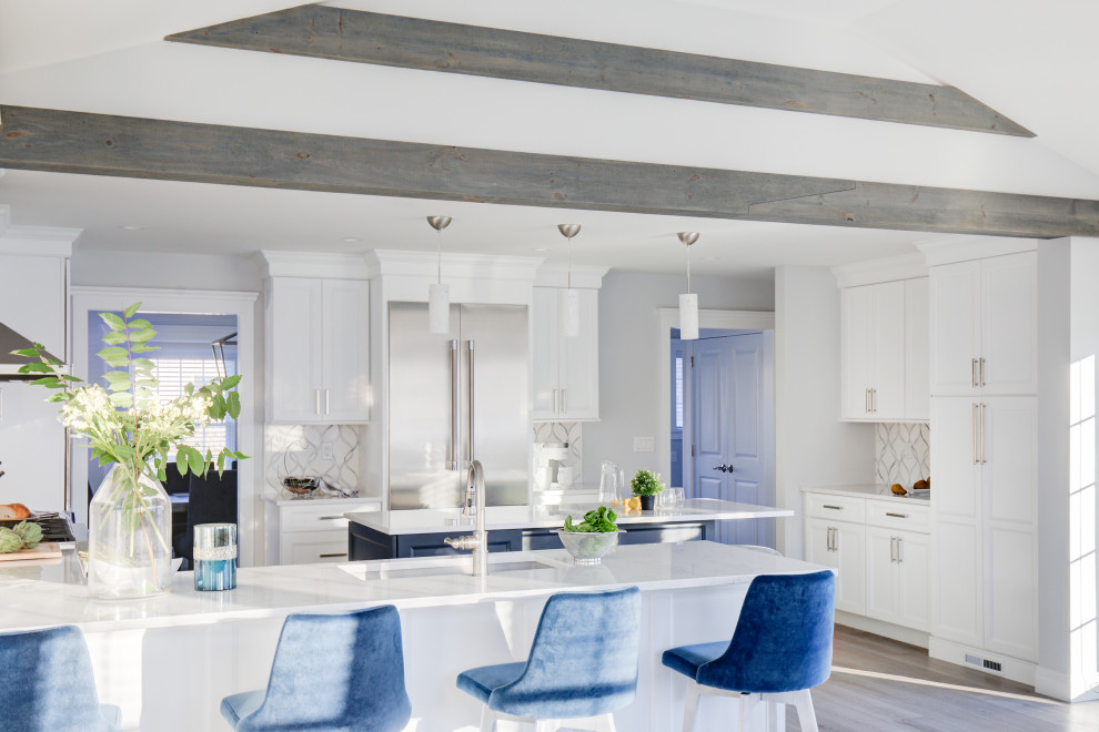 Bild på ett stort vintage vit vitt kök med öppen planlösning, med en undermonterad diskho, luckor med profilerade fronter, blå skåp, bänkskiva i kvarts, flerfärgad stänkskydd, rostfria vitvaror, vinylgolv, en köksö, grått golv och stänkskydd i marmor