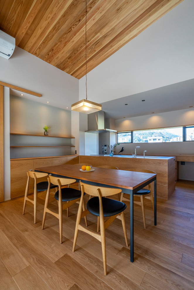 На фото: гостиная-столовая в стиле модернизм с белыми стенами, паркетным полом среднего тона, печью-буржуйкой, фасадом камина из бетона, коричневым полом, деревянным потолком и обоями на стенах с