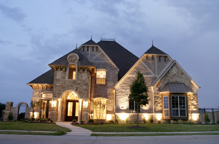 Inspiration for a large traditional two-storey beige exterior in Dallas with stone veneer.