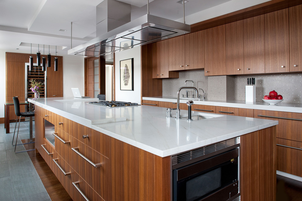 Design ideas for a contemporary galley eat-in kitchen in Boston with an undermount sink, flat-panel cabinets, medium wood cabinets, grey splashback, stainless steel appliances and with island.