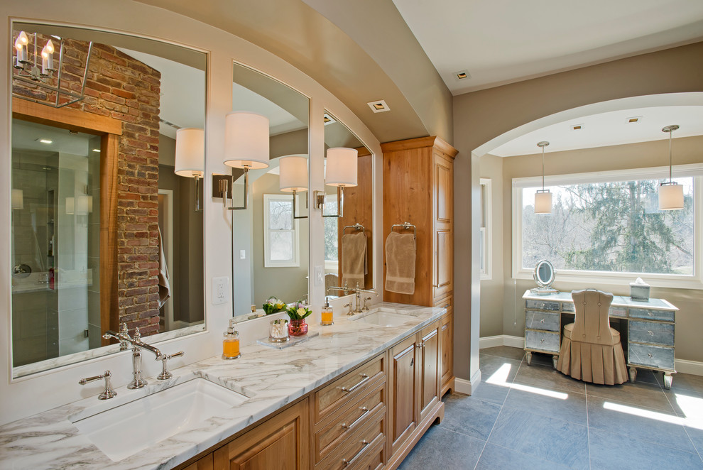 This is an example of a large traditional master bathroom in Baltimore with an undermount sink, raised-panel cabinets, medium wood cabinets, marble benchtops, a double shower and gray tile.