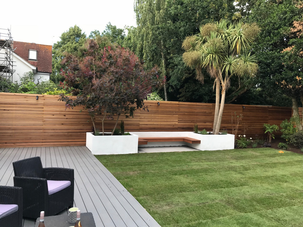 This is an example of a mid-sized contemporary partial sun backyard wood fence landscaping in London for summer.