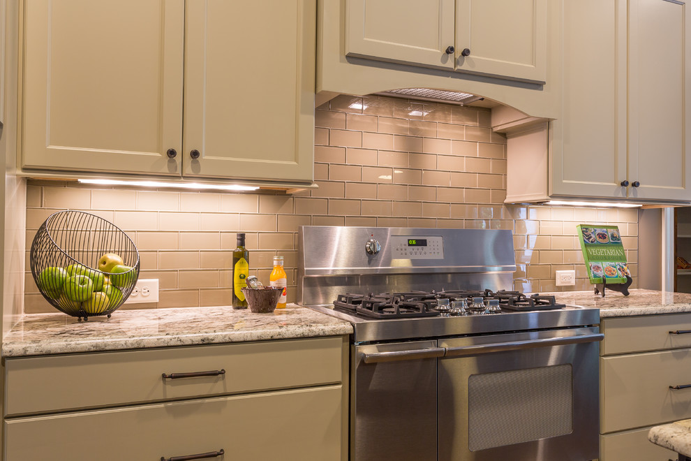 Inspiration for a mid-sized transitional single-wall kitchen in Raleigh with glass tile splashback, flat-panel cabinets, beige cabinets, granite benchtops, beige splashback and stainless steel appliances.