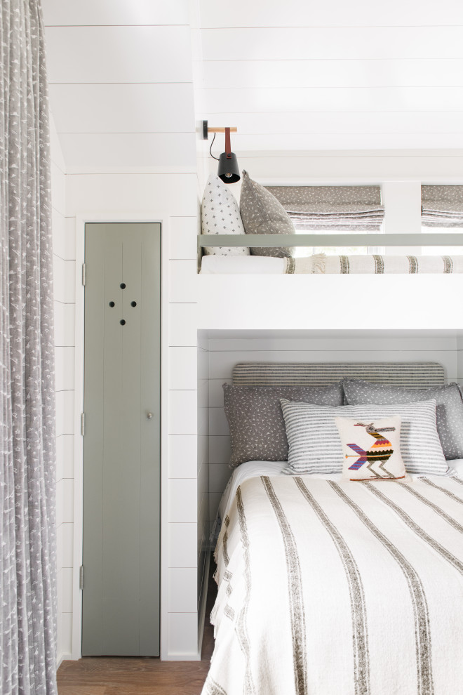 Sullivan's Island Remodel - Bunk bedroom featuring custom built-in bunk beds with white oak stair treads painted railing, niches with outlets and lighting, custom drapery and decorative lighting