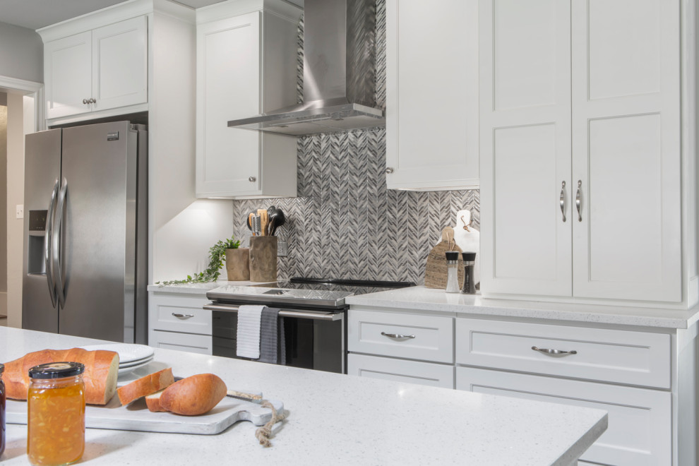 Example of a mid-sized transitional galley brown floor eat-in kitchen design with an undermount sink, shaker cabinets, white cabinets, quartzite countertops, beige backsplash, mosaic tile backsplash, stainless steel appliances, a peninsula and white countertops