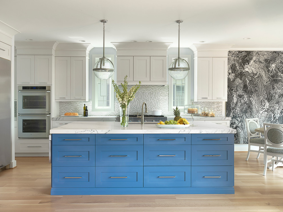 Example of a large transitional light wood floor eat-in kitchen design in St Louis with an undermount sink, shaker cabinets, blue cabinets, solid surface countertops, glass tile backsplash, stainless steel appliances, an island and gray backsplash