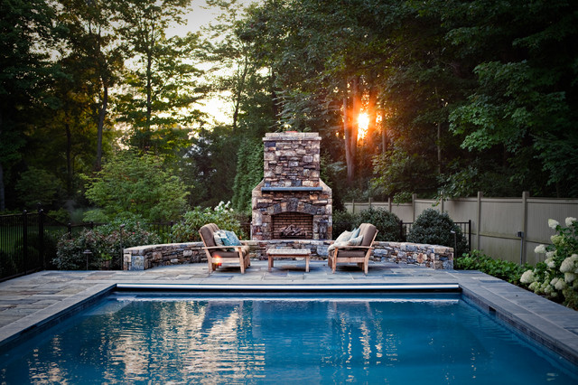 A modern inground pool and entertaining area with an outdoor gas fireplace for cooler nights