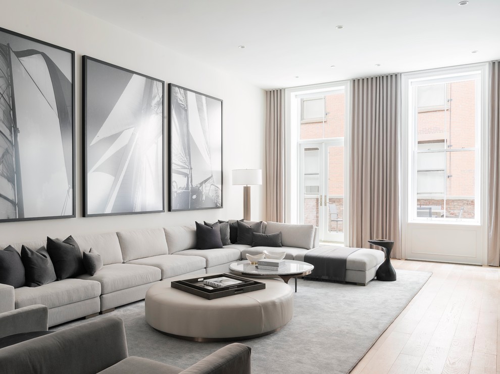 Contemporary living room in New York with white walls, light hardwood floors and beige floor.