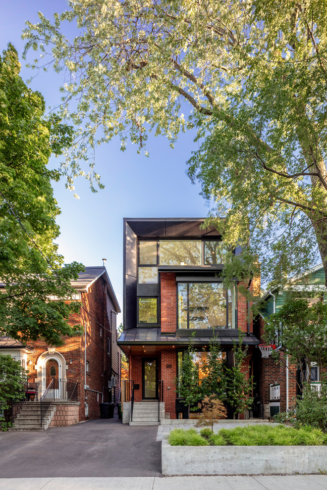 Inspiration for a red contemporary brick detached house in Toronto with three floors and a flat roof.