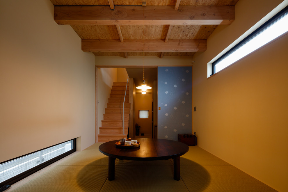 Modelo de comedor pequeño abierto con paredes beige, tatami, vigas vistas y madera