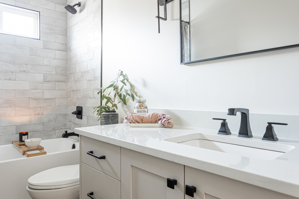 Design ideas for a mid-sized contemporary 3/4 bathroom in Vancouver with shaker cabinets, grey cabinets, an alcove tub, a one-piece toilet, gray tile, ceramic tile, white walls, vinyl floors, an undermount sink, quartzite benchtops, brown floor, multi-coloured benchtops, a single vanity and a built-in vanity.