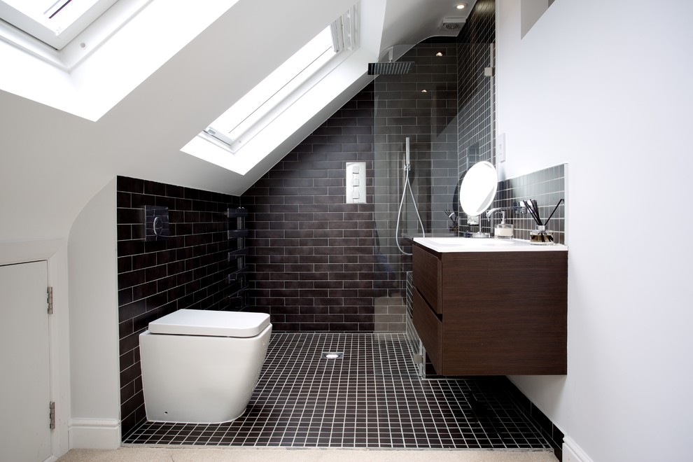 This is an example of a contemporary bathroom in London with flat-panel cabinets, a curbless shower, a one-piece toilet, black tile, subway tile, black walls, ceramic floors and dark wood cabinets.