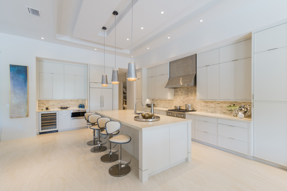 Large mediterranean l-shaped kitchen in Miami with an undermount sink, recessed-panel cabinets, white cabinets, grey splashback, porcelain splashback, stainless steel appliances, porcelain floors, with island, beige floor and white benchtop.