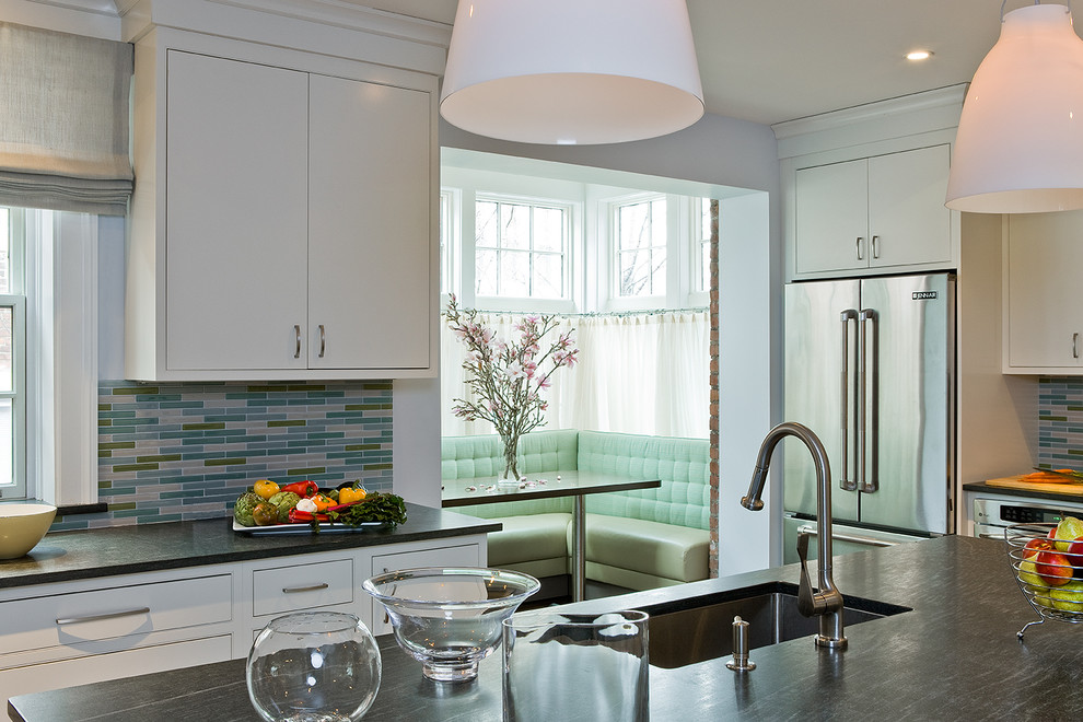 Contemporary eat-in kitchen in Boston with a single-bowl sink, beaded inset cabinets, white cabinets, multi-coloured splashback, matchstick tile splashback and stainless steel appliances.