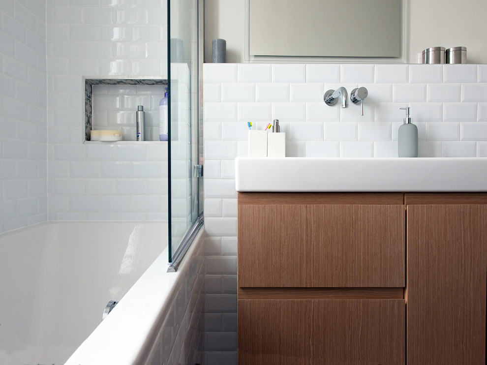 Design ideas for a mid-sized contemporary master bathroom in Paris with medium wood cabinets, a drop-in tub, white tile, white walls, subway tile and a console sink.