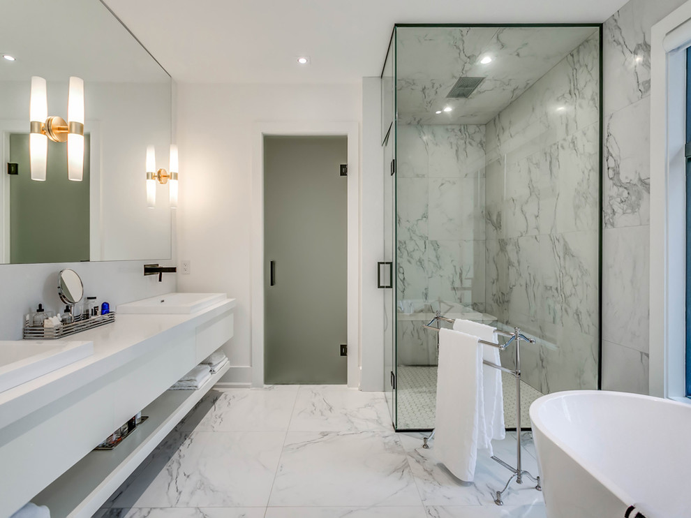 This is an example of a contemporary master bathroom in Toronto with open cabinets, white cabinets, a freestanding tub, a corner shower, white tile, marble, white walls, marble floors, a drop-in sink, quartzite benchtops, white floor, a hinged shower door and white benchtops.