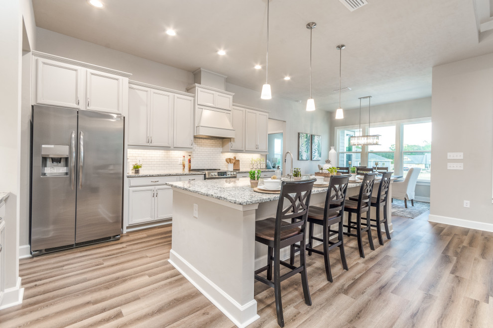 Mid-sized transitional galley vinyl floor and multicolored floor eat-in kitchen photo with a farmhouse sink, recessed-panel cabinets, granite countertops, white backsplash, subway tile backsplash, stainless steel appliances, an island, multicolored countertops and gray cabinets