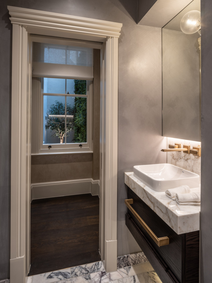 Photo of a small traditional master bathroom in London with flat-panel cabinets, brown cabinets, an open shower, a wall-mount toilet, blue tile, marble, grey walls, mosaic tile floors, marble benchtops, purple floor, an open shower, multi-coloured benchtops, a single vanity and a built-in vanity.