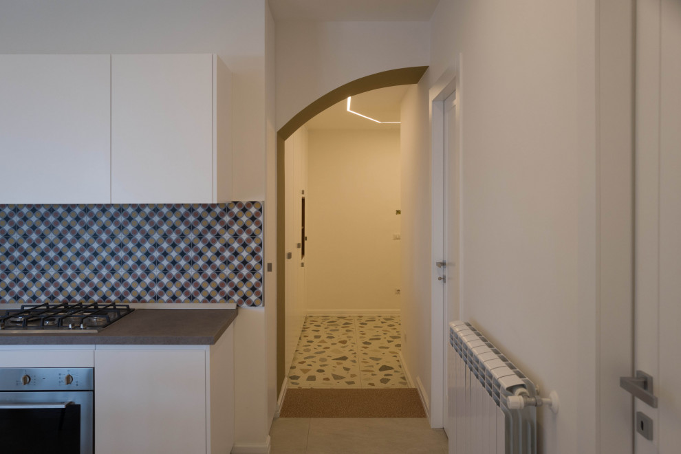 Cette image montre une entrée design de taille moyenne avec un mur blanc, un sol en carrelage de porcelaine, une porte blanche, un sol multicolore et un plafond décaissé.