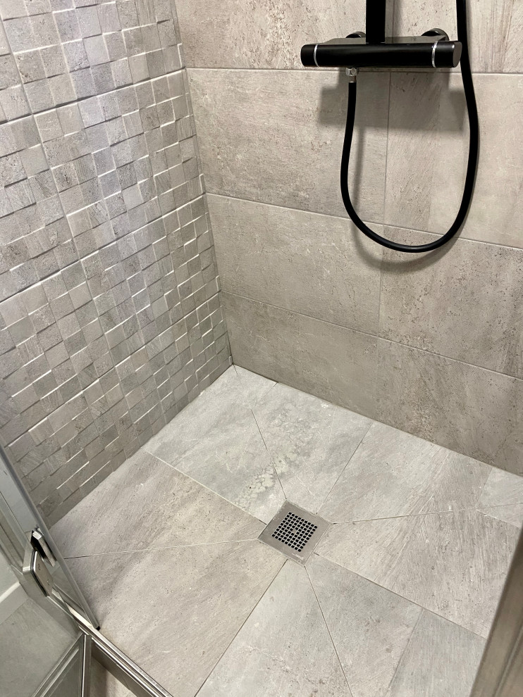 Photo of a small modern 3/4 bathroom in Paris with flat-panel cabinets, grey cabinets, a corner shower, gray tile, ceramic tile, grey walls, ceramic floors, an undermount sink, laminate benchtops, grey floor, a hinged shower door, white benchtops, a single vanity and a floating vanity.