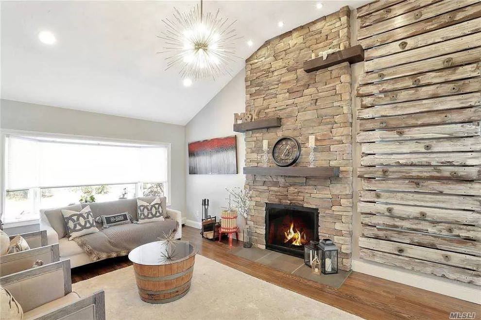 Inspiration for a country open concept living room in New York with grey walls, a standard fireplace and brown floor.