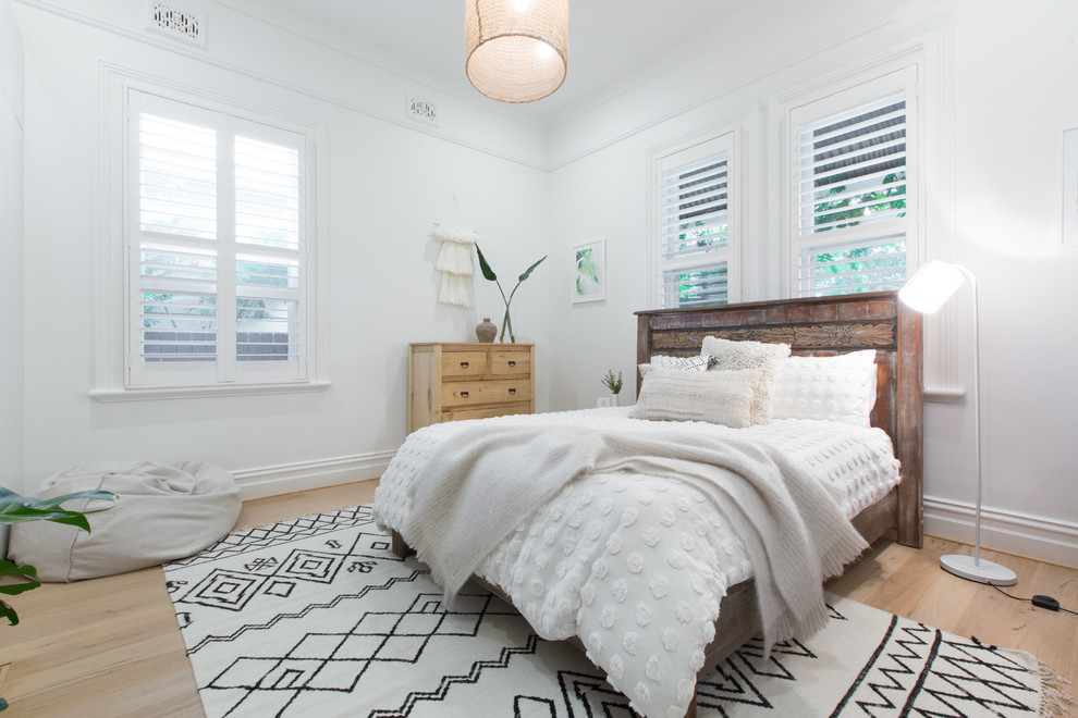 Mid-sized beach style bedroom in Sydney with white walls, light hardwood floors and no fireplace.