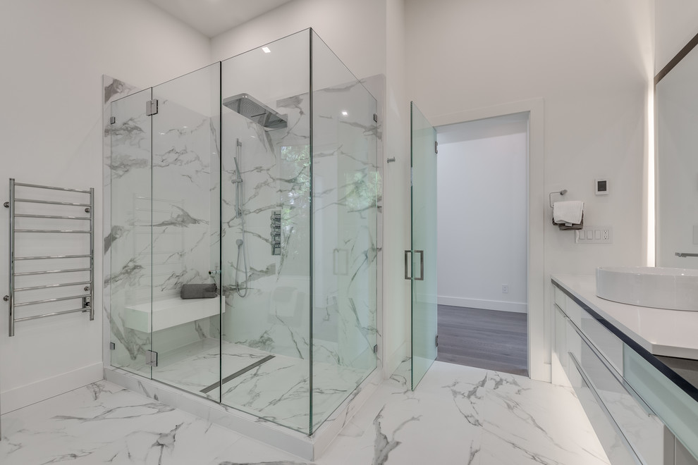 Modern master bathroom in Vancouver with glass-front cabinets, white cabinets, a freestanding tub, an open shower, white tile, stone tile, white walls, marble floors, a vessel sink, engineered quartz benchtops, white floor, a hinged shower door, white benchtops and a wall-mount toilet.