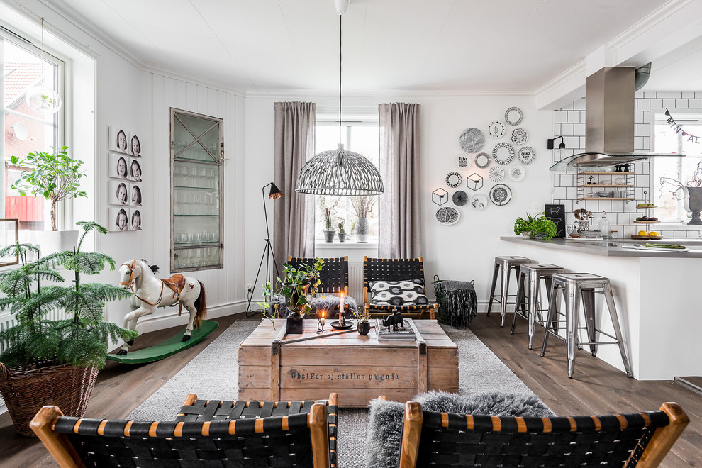 Large scandinavian open concept living room in Gothenburg with white walls and dark hardwood floors.