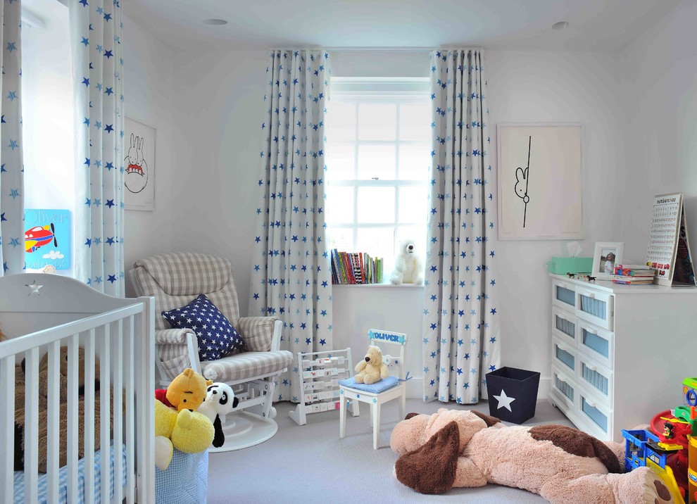 Photo of a mid-sized transitional nursery for boys in London with white walls, carpet and grey floor.