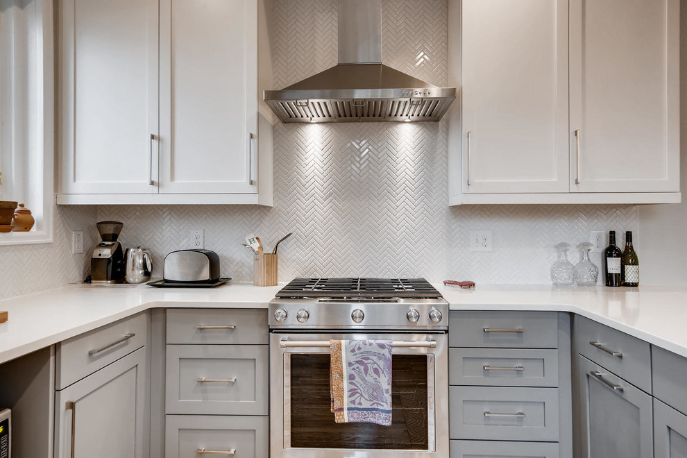 Inspiration for a small transitional u-shaped light wood floor and brown floor eat-in kitchen remodel in Denver with an undermount sink, shaker cabinets, white cabinets, granite countertops, white backsplash, ceramic backsplash, stainless steel appliances, a peninsula and white countertops