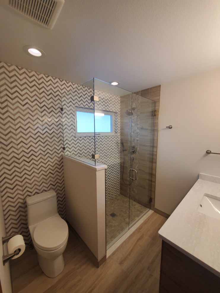 Small transitional master bathroom in Denver with shaker cabinets, brown cabinets, a corner shower, a one-piece toilet, beige tile, white walls, porcelain floors, an undermount sink, brown floor, a hinged shower door, white benchtops, a niche, a single vanity and a floating vanity.