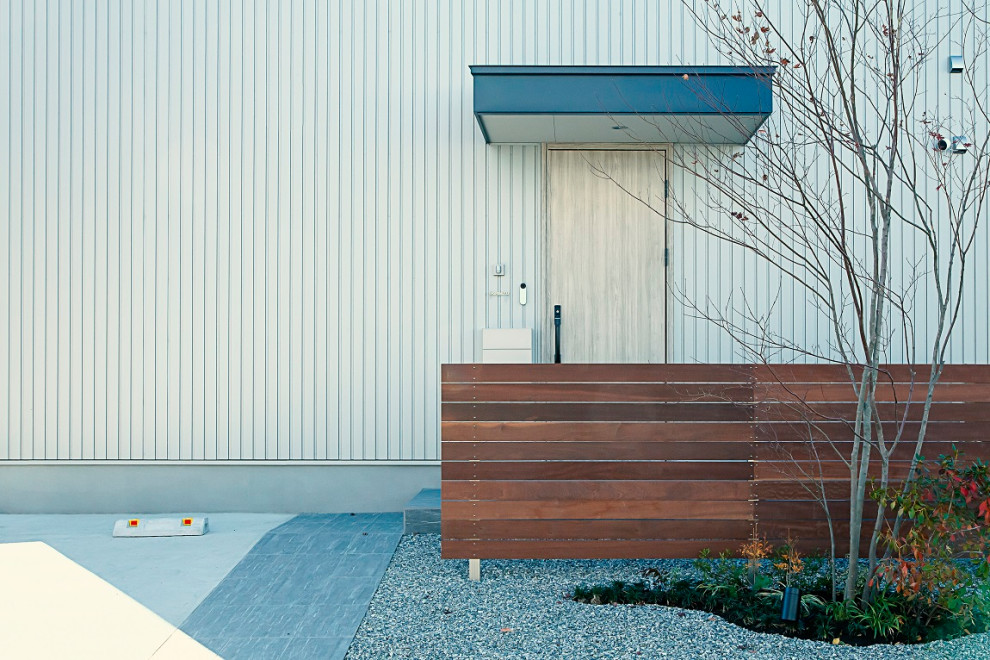 Стильный дизайн: двухэтажный, серый частный загородный дом в скандинавском стиле с облицовкой из металла, двускатной крышей, металлической крышей, синей крышей и отделкой доской с нащельником - последний тренд
