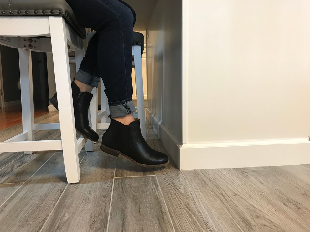 Inspiration for a mid-sized transitional l-shaped porcelain tile and gray floor open concept kitchen remodel in Boston with a single-bowl sink, flat-panel cabinets, white cabinets, quartz countertops, gray backsplash, subway tile backsplash, stainless steel appliances, an island and white countertops