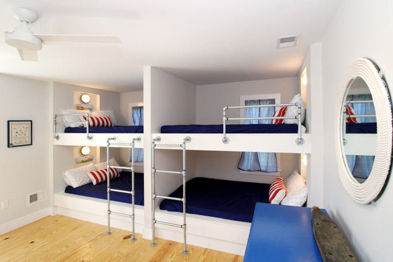 Mid-sized beach style gender-neutral kids' bedroom in Boston with white walls and light hardwood floors.