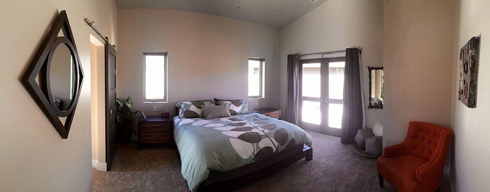 Photo of a small industrial master bedroom in Denver with beige walls and carpet.