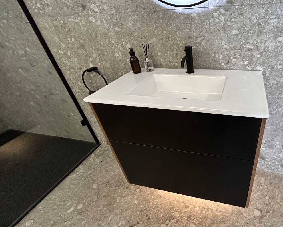 Photo of a medium sized modern grey and black family bathroom in Surrey with flat-panel cabinets, black cabinets, a corner shower, a wall mounted toilet, multi-coloured tiles, porcelain tiles, grey walls, porcelain flooring, a submerged sink, grey floors, a sliding door, a wall niche, a single sink, a floating vanity unit and a coffered ceiling.