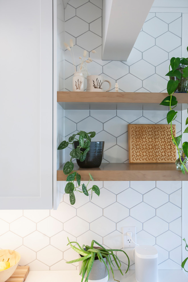 Mid-sized transitional l-shaped eat-in kitchen photo with an undermount sink, blue cabinets, quartz countertops, white backsplash, porcelain backsplash, stainless steel appliances, no island and white countertops