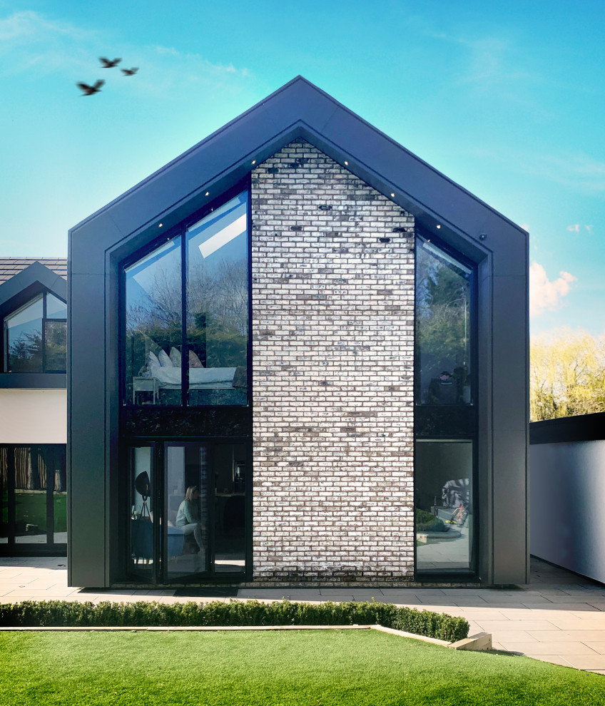 Idee per la villa grigia contemporanea a due piani di medie dimensioni con rivestimento in metallo, tetto a capanna, copertura mista, tetto grigio e pannelli e listelle di legno