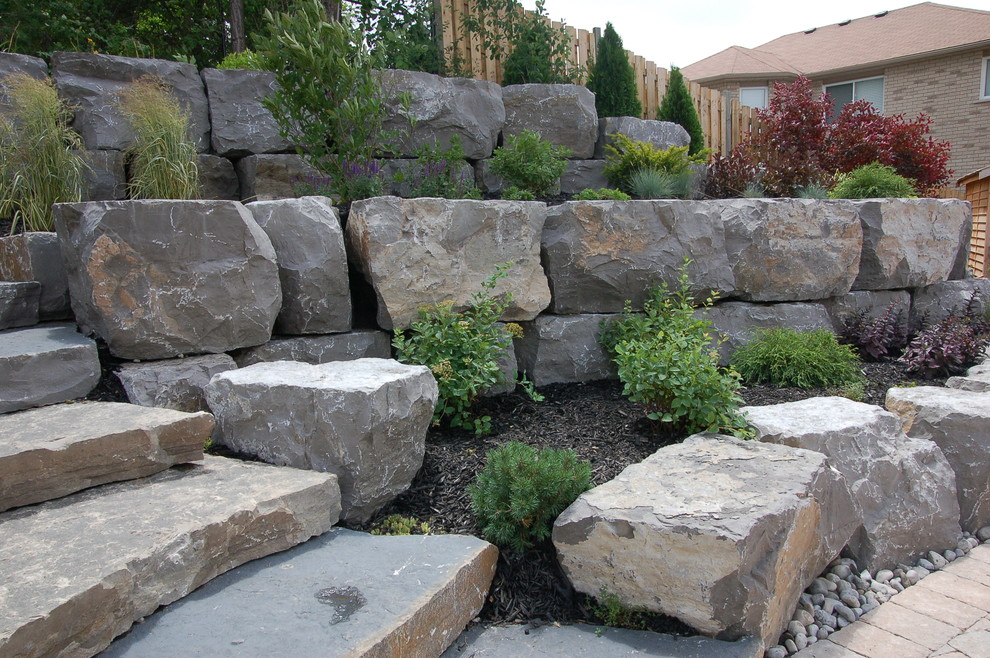 This is an example of a country garden in Toronto with a retaining wall.