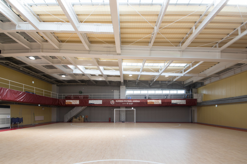 Geräumiger Nordischer Fitnessraum mit Indoor-Sportplatz, grauer Wandfarbe und freigelegten Dachbalken in Tokio